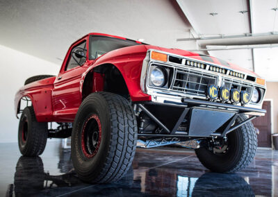 Red off-road truck with Switch-Pros electrical system for vehicle power management.